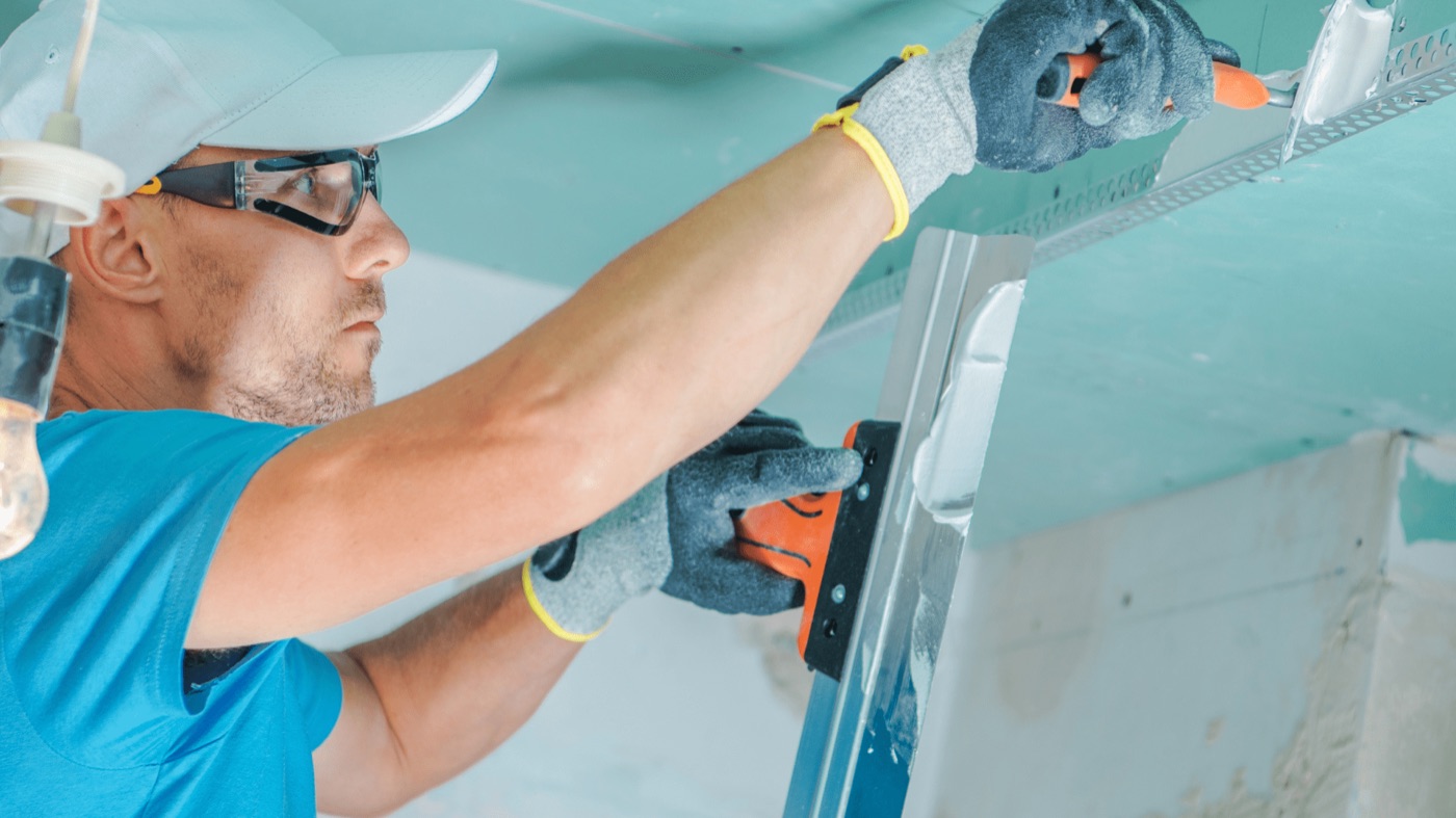 A commercial painter spray-finishing shutters for a Miami business