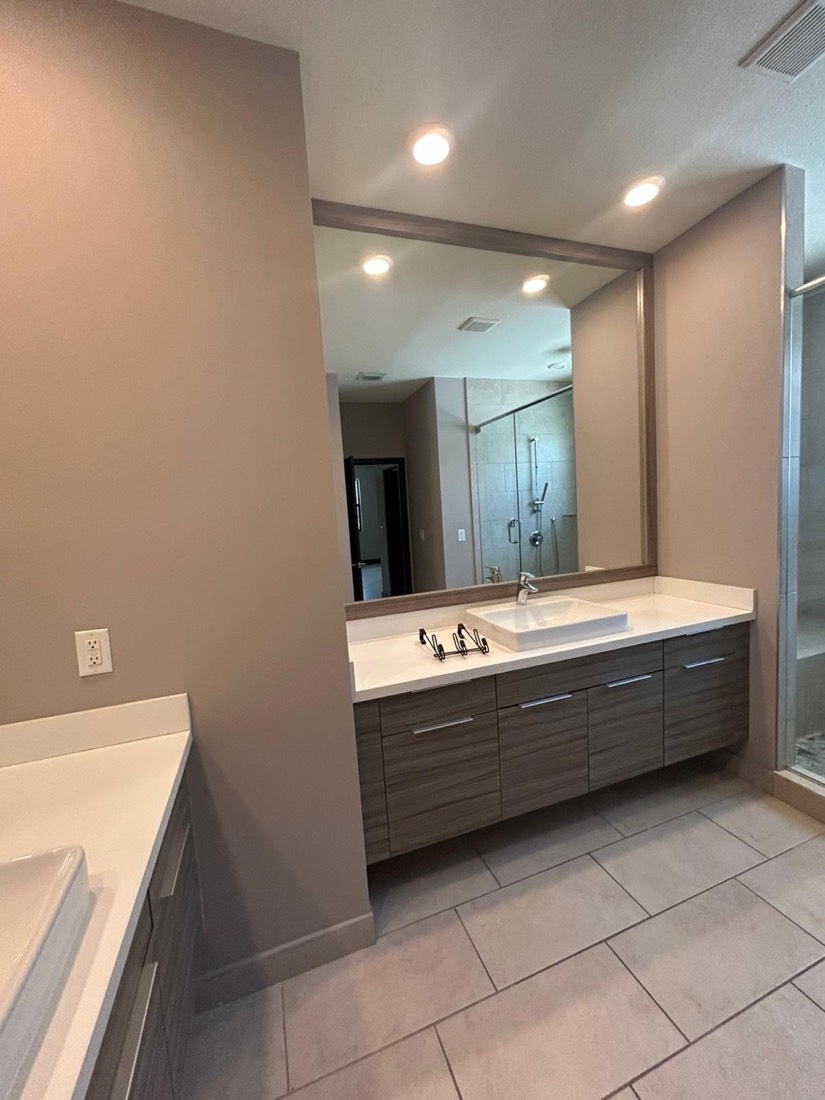 Bathroom vanity remodel with fresh paint and a large mirror