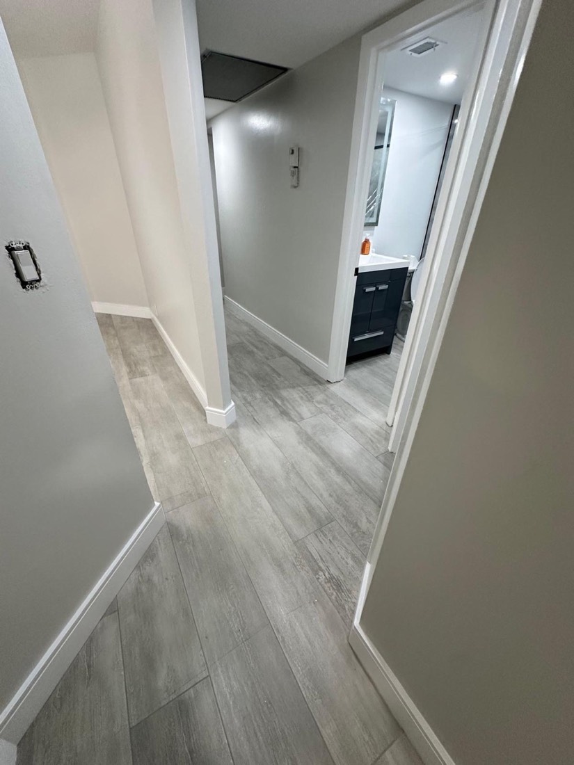 Renovated hallway with gray wood floors and fresh white walls