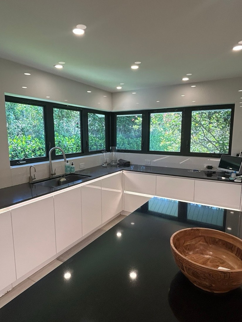 Repainted kitchen with crisp white cabinets and dark countertops