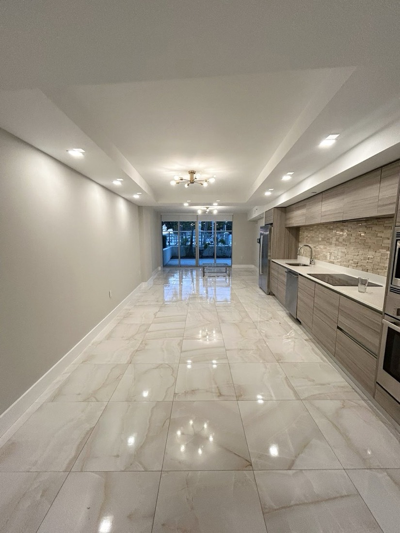 Open-concept kitchen renovation with marble floors and fresh white paint in Miami