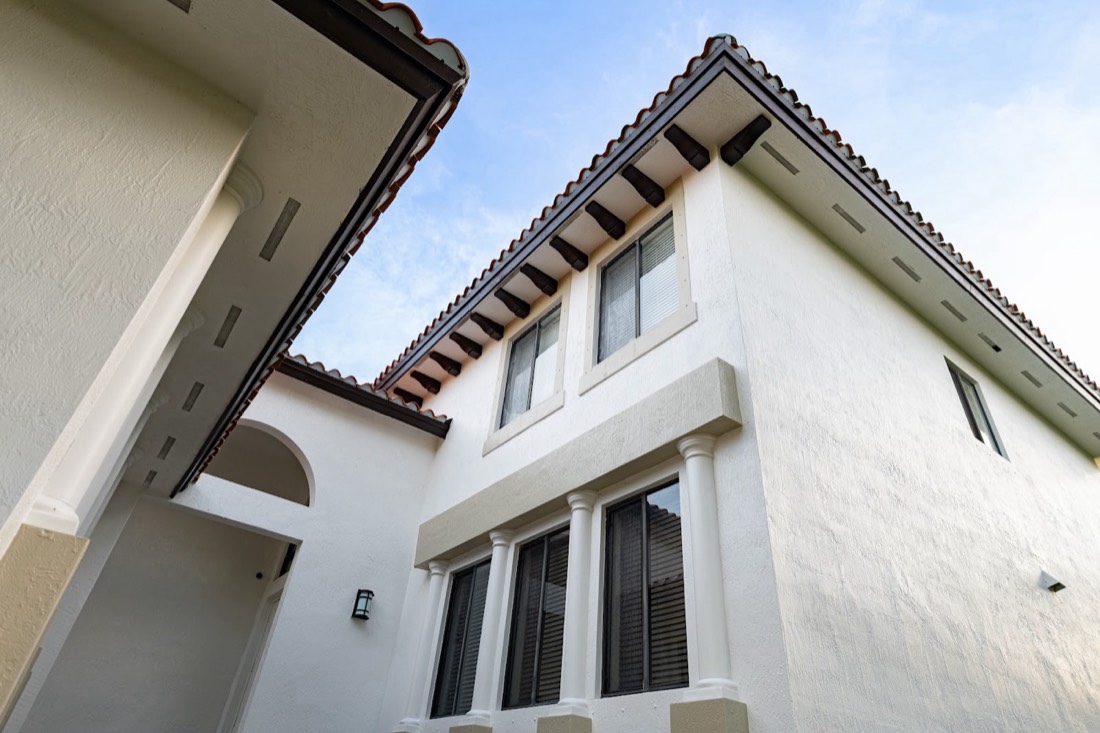 White stucco exterior with dark roof trim after an exterior repaint