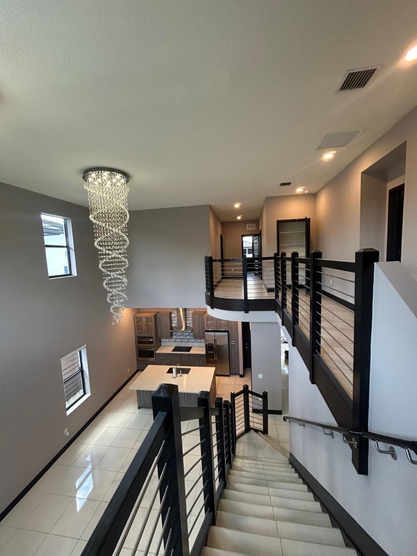 Two-story foyer with a chandelier after interior painting